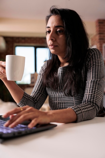 Photo gratuite employé de bureau travaillant à distance sur un ordinateur portable, faisant un rapport d'activité avec une application réseau à la maison sur un ordinateur. travailler sur des informations de recherche de démarrage et étudier en ligne, leçon de classe.