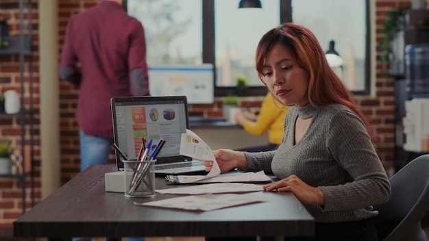 Employé de bureau utilisant des documents et un ordinateur portable pour planifier la présentation du leadership dans le bureau de démarrage. Employé de l'entreprise travaillant sur la croissance des ventes pour le développement financier et le commerce électronique en ligne.