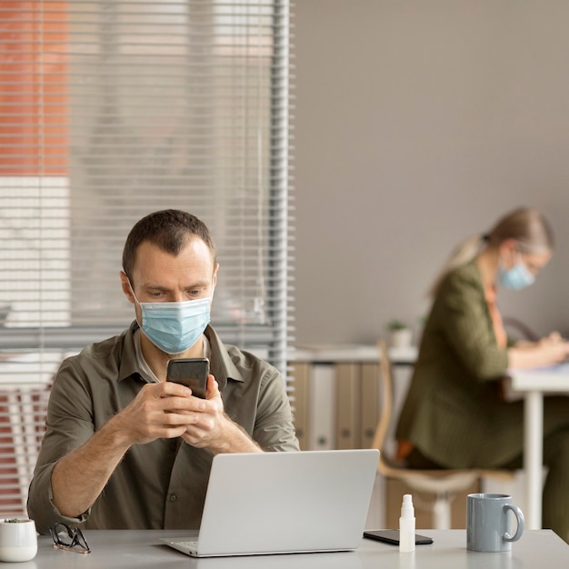 Employé portant un masque facial au bureau