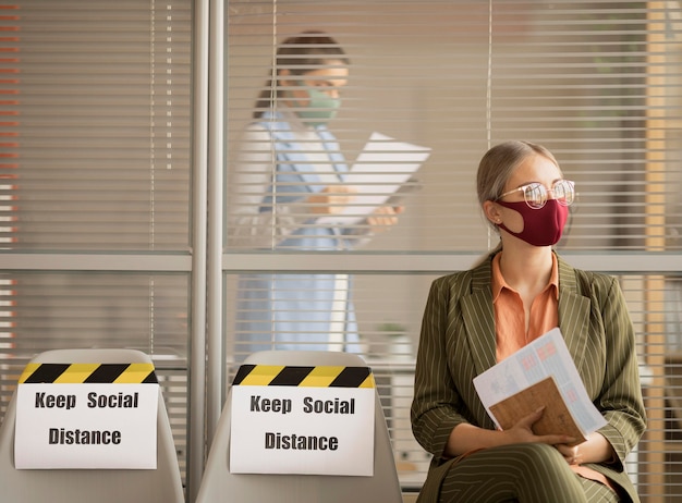 Photo gratuite employé portant un masque facial prenant une pause