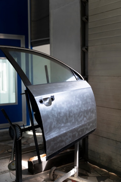 Employé de service peignant une voiture en service automobile