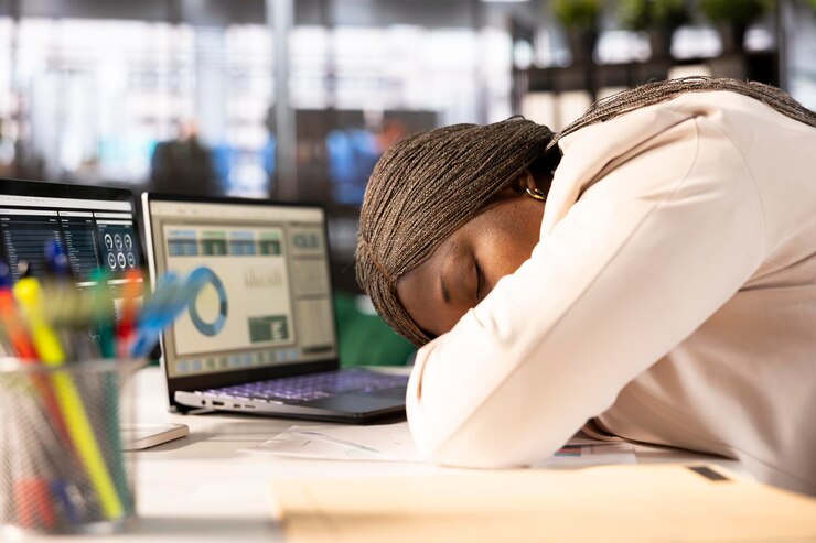 Photo gratuit un employé surmené s'endort à son bureau en regardant les statistiques.