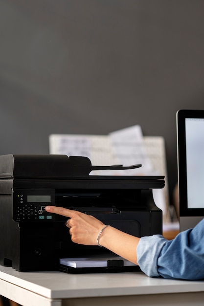 Photo gratuite employé de vue latérale utilisant une imprimante au travail