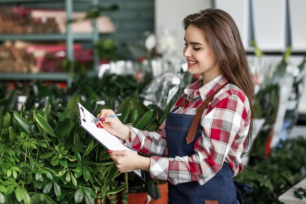 Employée du centre floral vérifiant les fleurs dans son centre moderne