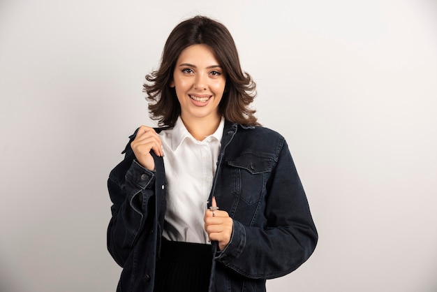 Employée heureuse debout sur blanc.