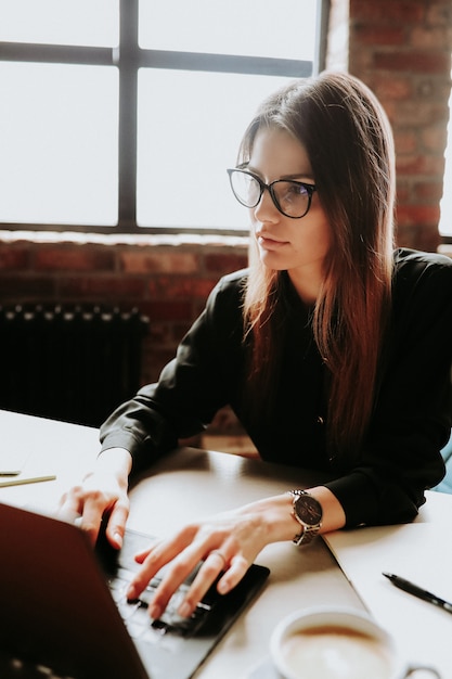 Employée travaillant au bureau avec de grandes fenêtres