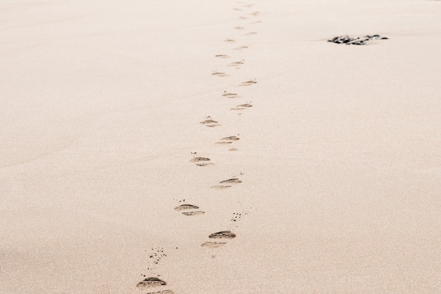 Empreintes de pas d'un homme sur le sable du désert par une journée ensoleillée