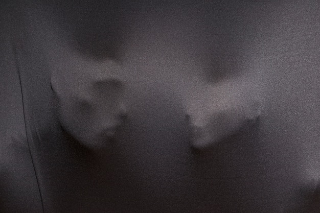 Empreintes de visages humains sur un tissu gris