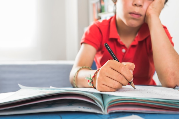 Photo gratuite enfant d'âge préscolaire, terminer l'exercice assis à table