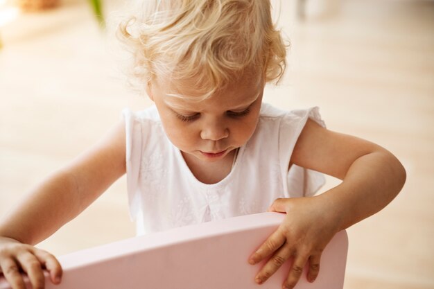 Enfant à angle élevé jouant avec une chaise