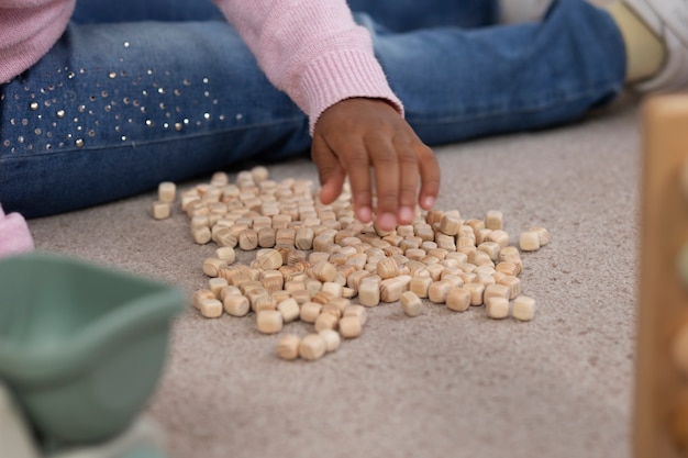 Photo gratuite enfant à angle élevé jouant avec des pièces en bois