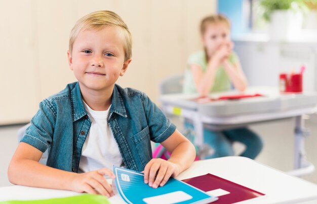 Enfant blond assis à son bureau