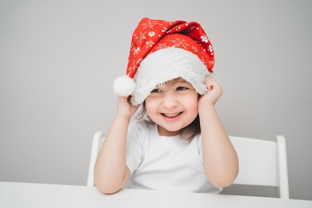 Un enfant en bonnet du nouvel an fait un vœu le bébé les yeux fermés attend un mira de noël...
