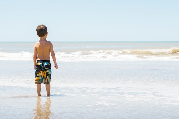 Photo gratuite enfant sur le bord de la mer dans l'eau