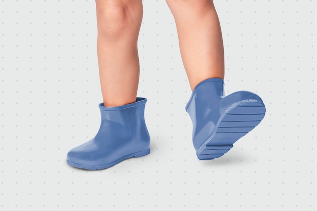 Photo gratuite enfant avec des bottes en caoutchouc bleues