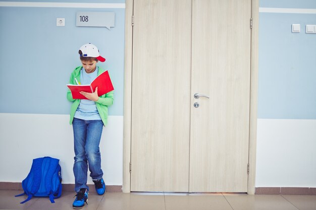 Enfant avec bouchon à faire ses devoirs