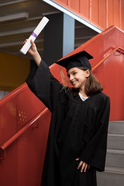 Enfant célébrant l'obtention du diplôme de maternelle