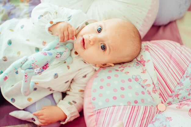 Enfant à cheveux courts couché dans son lit