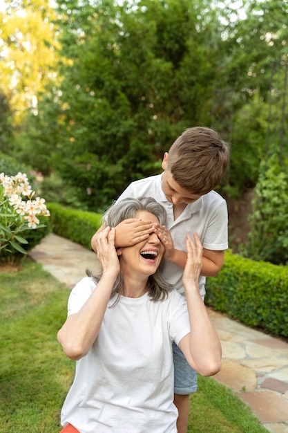 Enfant de coup moyen couvrant les yeux de la femme