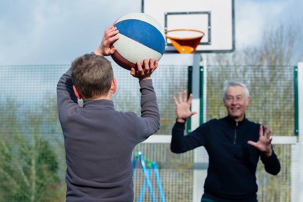 Enfant de coup moyen et grand-père jouant au jeu