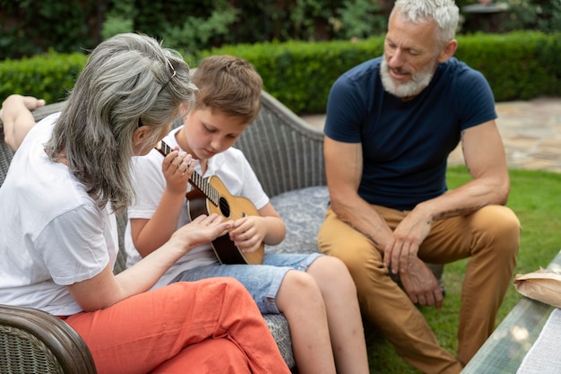 Enfant de coup moyen jouant de la musique pour les grands-parents