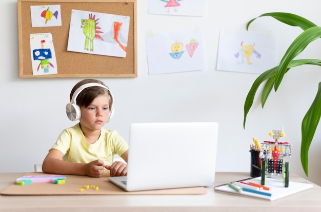 Enfant de coup moyen regardant un ordinateur portable