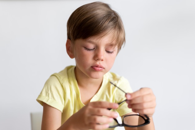 Enfant de coup moyen tenant des lunettes