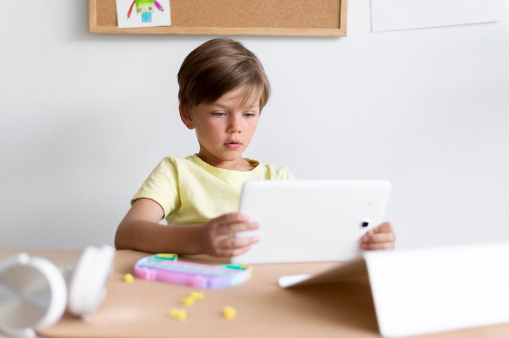 Photo gratuit enfant de coup moyen tenant une tablette
