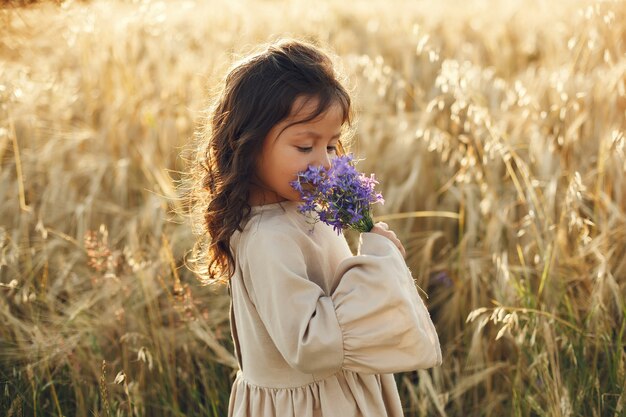Enfant dans un champ d'été. Petite fille dans une jolie robe marron.