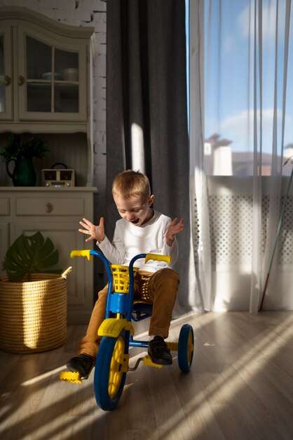 Enfant excité plein coup sur tricycle à la maison