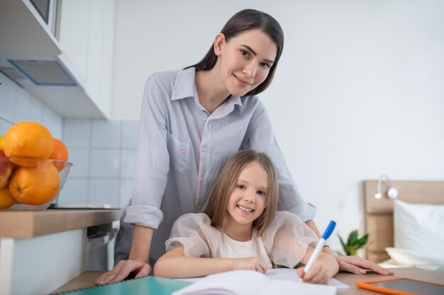 Enfant à faire ses devoirs aidé par sa mère