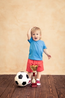 L'enfant fait semblant d'être un joueur de football. concept de réussite et de gagnant
