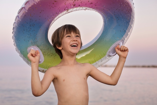 Enfant avec flotteur au bord de la mer