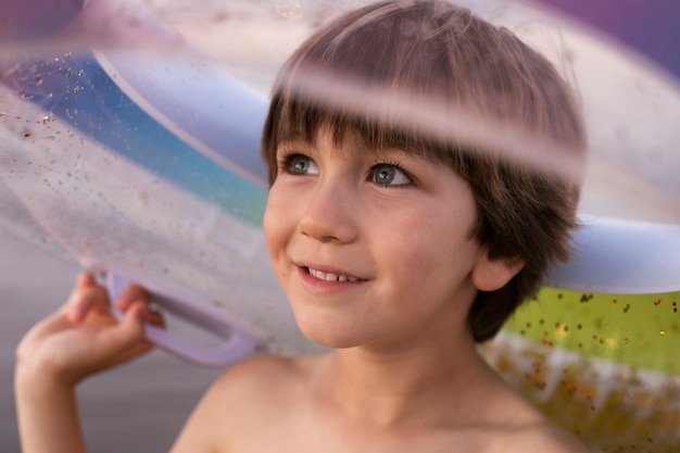 Enfant avec flotteur au bord de la mer