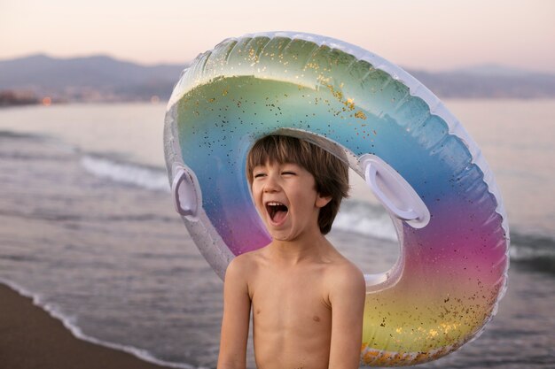 Enfant avec flotteur au bord de la mer