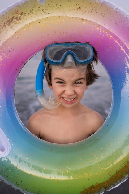 Enfant avec flotteur au bord de la mer