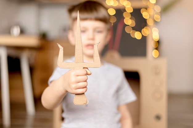 Photo gratuite enfant flou avec poignard en carton