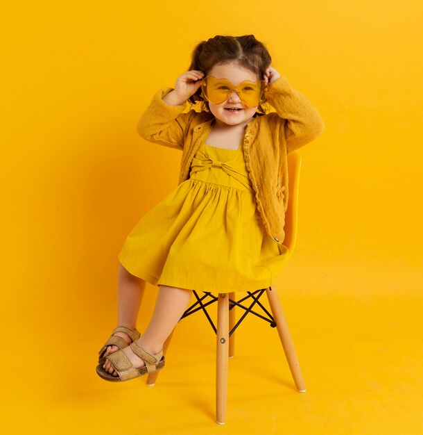 Enfant heureux posant tout en portant des lunettes de soleil