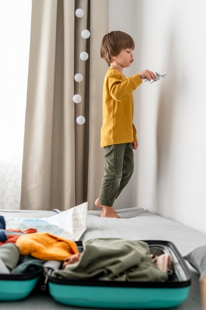 Enfant à homer avec bagages et figurine d'avion