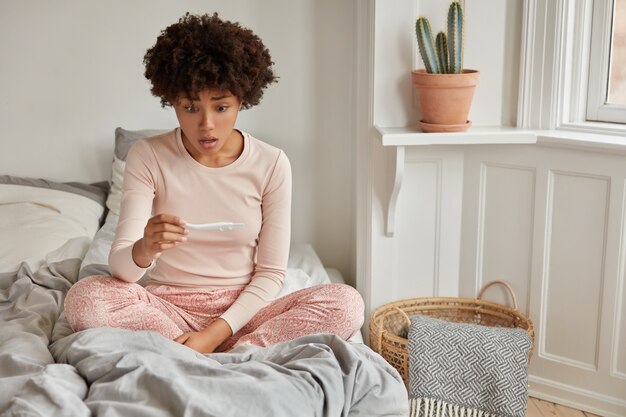 Enfant indésirable. Choqué, jeune femme à la peau foncée regarde avec perplexité