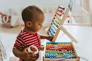 Photo gratuite enfant jouant avec un boulier en bois coloré