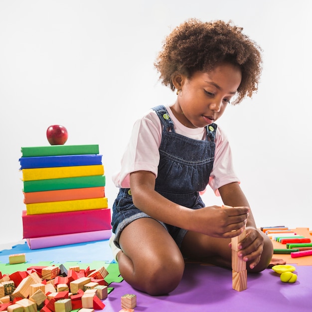 Photo gratuite enfant jouant avec des cubes sur le tapis de jeu en studio