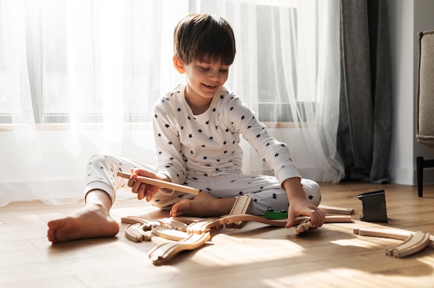 Photo gratuite enfant jouant avec des morceaux de bois plein coup