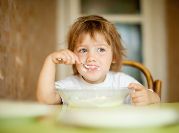 L&#39;enfant mange avec une cuillère