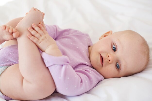 Enfant mignon jouant avec ses jambes