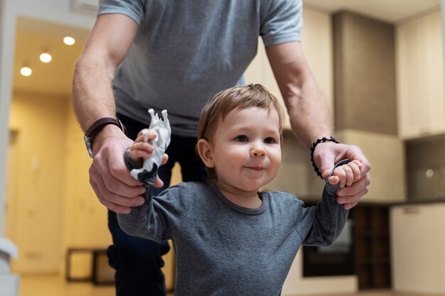 Enfant mignon marchant à l'intérieur avec son père