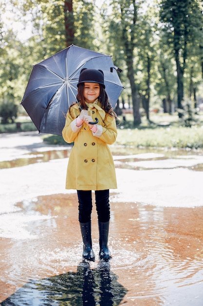 Photo gratuite enfant mignon plaiyng un jour de pluie