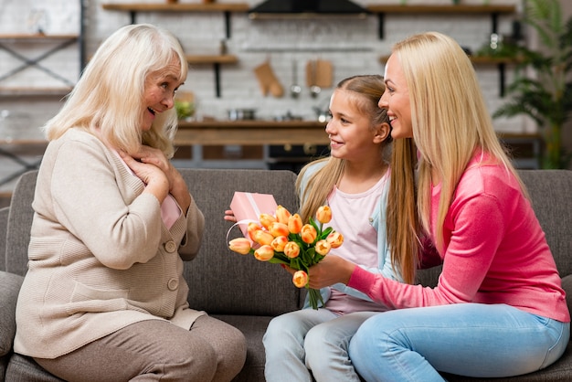 L'enfant offre un bouquet de fleurs à sa grand-mère