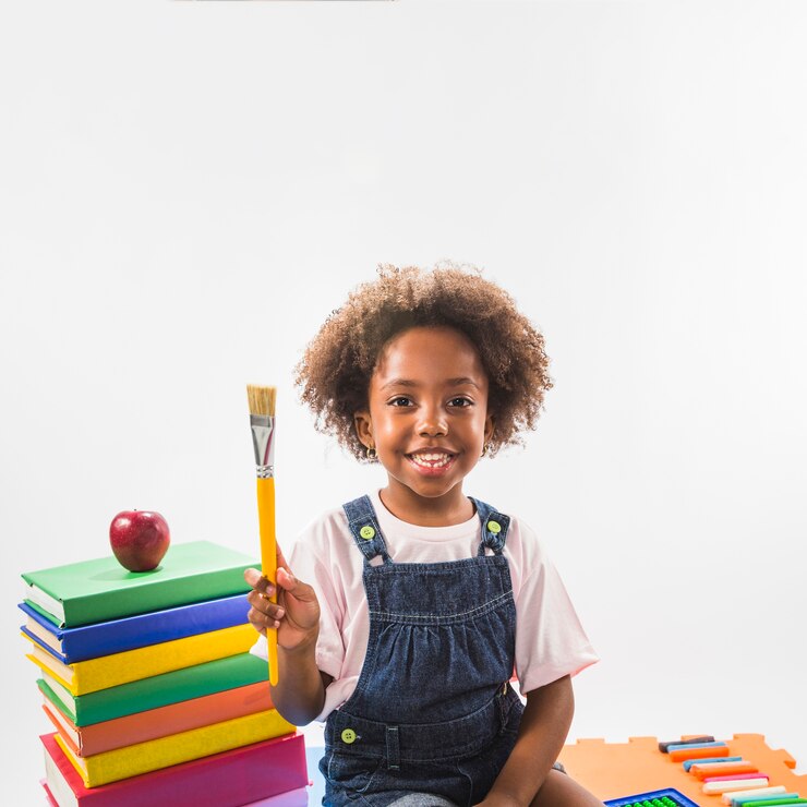 Photo gratuit enfant avec pinceau et livres en studio