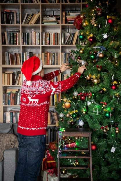 Enfant de plan moyen décorant l'arbre